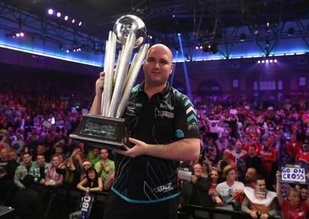 Rob Cross clutches the William Hill World Darts Championship trophy at Alexandra Palace. Picture courtesy Lawrence Lustig/PDC