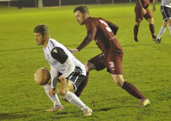 Bexhill United wide player Jack Shonk brings the ball under control, watched closely by Alfold full-back Zach Gray. Pictures by Simon Newstead