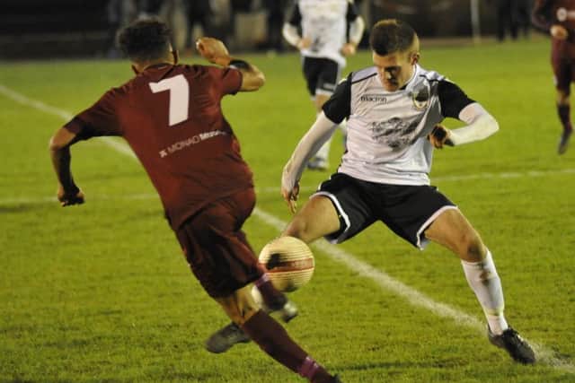 Bexhill United midfielder Jamie Bunn goes in for a tackle with Alfold's Sam Lemon
