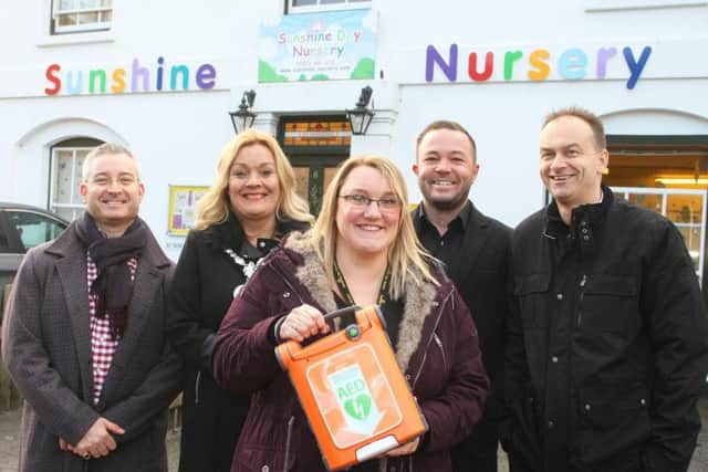 Nursery manager Allie Wolke holding the defibrillator with (from left) Jason Palmer, Joss Loader, chairman of Adur District Council, Joe Pelling and Kevin Allen