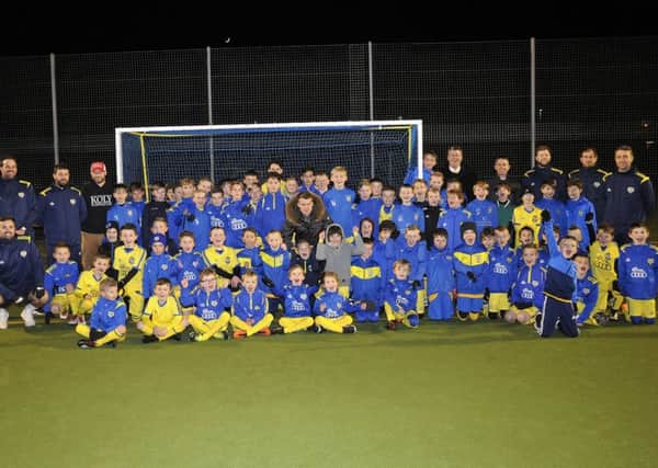 Solly March (centre) lines up with the Flair Academy footballers