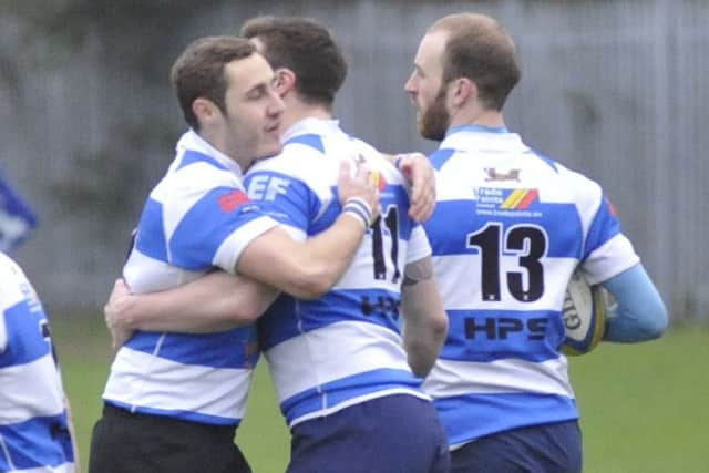 Sills is congratulated by a pair of team-mates after scoring his try