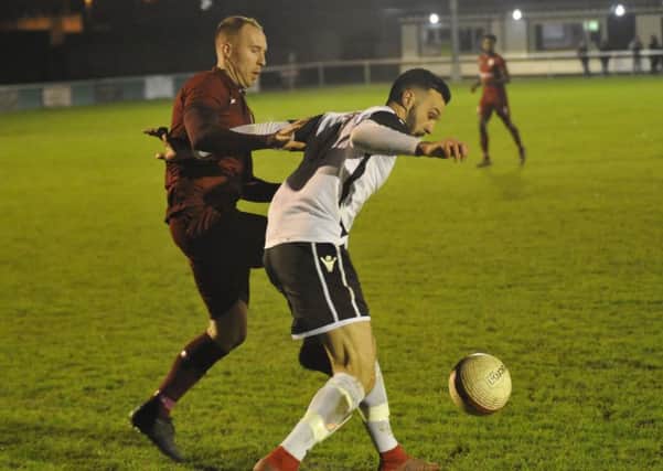 Bexhill United wide player Jack McLean holds off Alfold full-back Gav Fowler at The Polegrove on Tuesday night. Pictures by Simon Newstead