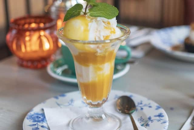 Coconut ice cream with mango sauce  and coconut flakes