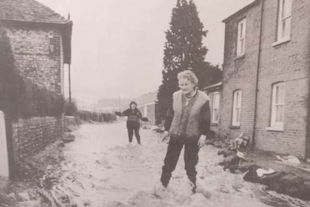 Dorothy Henly and Suzanne Padley struggle along the road which had turned into a river outside their home at Brooklands Cottages, Walderton