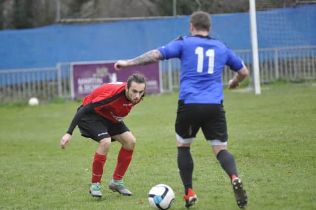 A Sedlescombe Rangers defender keeps a close eye on Hollington United attacking player Allan McMinigal
