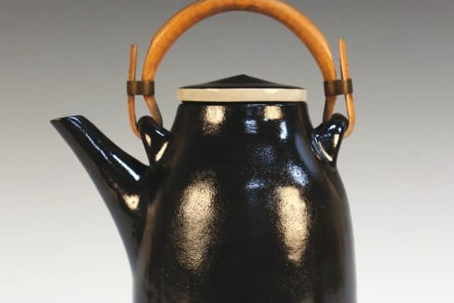 This Lucie Rie stoneware teapot and cover with its dark brown/black shiny glaze beneath an applied bamboo handle was purchased from Heal's in the 1950s. SUS-190121-113808001