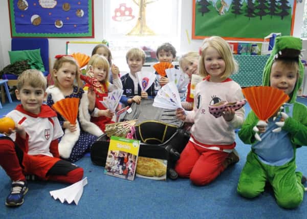 Younger children at Westbourme House explore the contents of a country-themed suitcase. Spain in this case