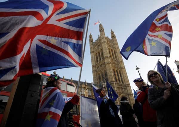 Anti-brexit campaigners wave Union and EU flags outside the Houses of Parliament