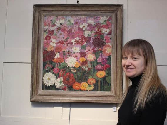 The painting by Sir Cedric Morris with auctioneer Lucy Homer