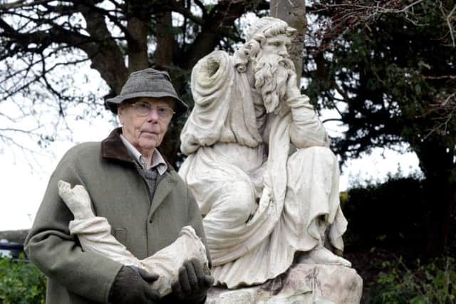 Chichester resident David Hide, standing in front of the Coade stone statue in Priory Park. Calls have been made to speed up plans for its restoration