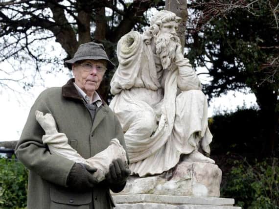 Chichester resident David Hide, standing in front of the Coade stone statue in Priory Park. Calls have been made to speed up plans for its restoration