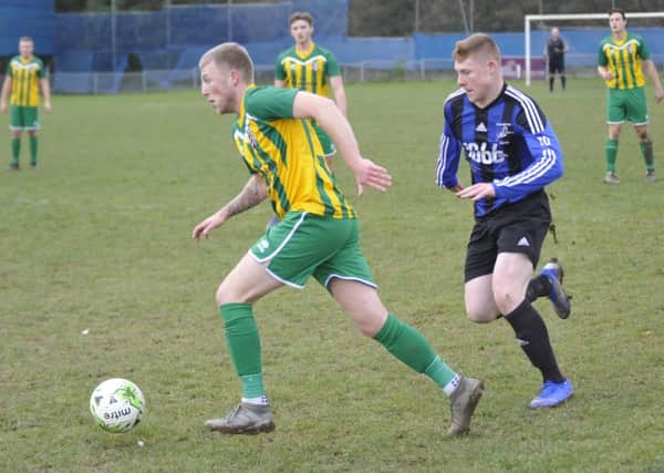 Jay Tomlin chases the AFC Uckfield Town II player in possession during Hollington United's 3-1 victory at Gibbons Field yesterday. Picture by Simon Newstead