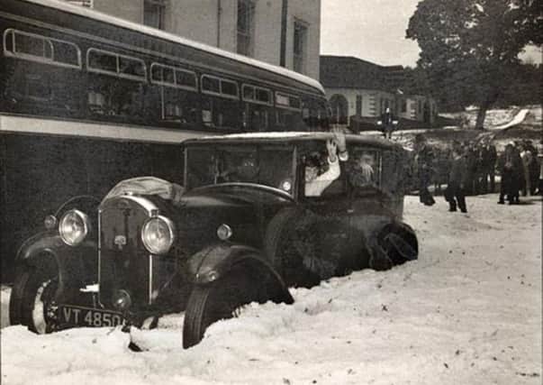 This vintage snap shows a car stranded in the snow.