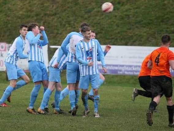 Worthing United attempt to clear their lines against Mile Oak. Picture: Derek Martin