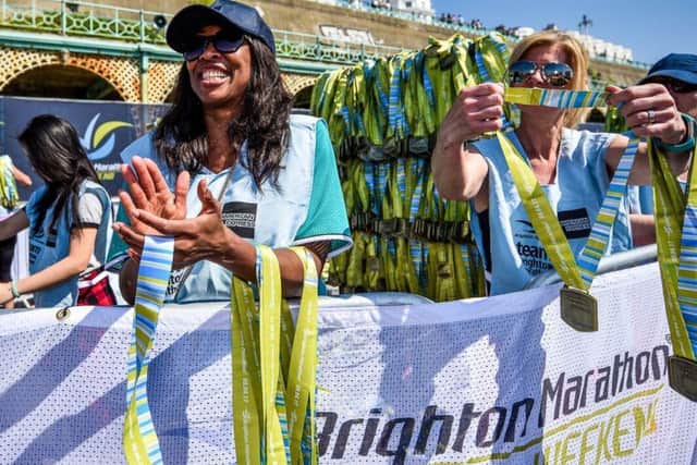 Volunteers handing out medals at the Brighton Marathon Weekend