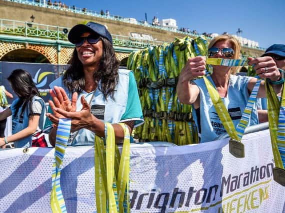 Volunteers handing out medals at the Brighton Marathon Weekend