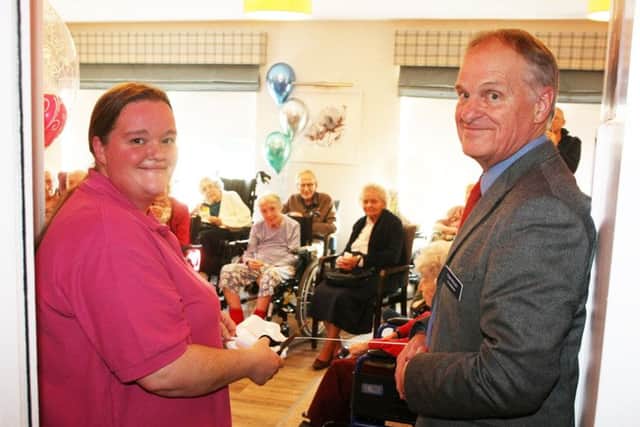 Amy Holder, activities co-ordinator, cuts the ribbon accompanied by chairman Tom Ridley. Photo by Derek Martin DM1912853a