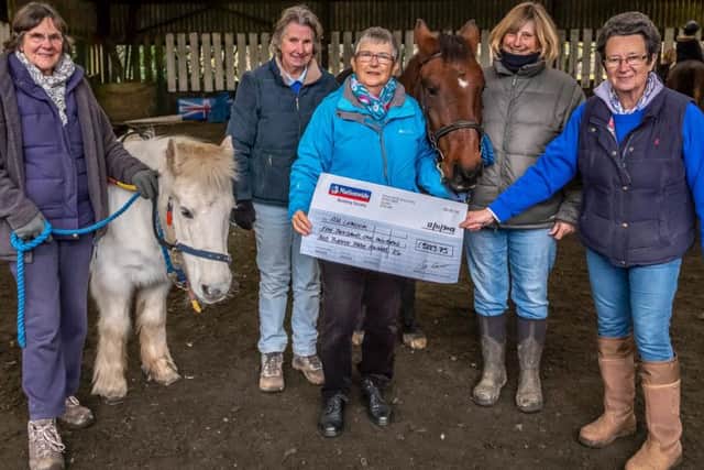 Cowdray Park outgoing ladies' captain Margaret Curwood presents a cheque to Riding for the Disabled