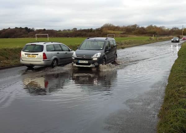 Cars drive through water on Freshfields, leading to the landfill site, in St Leonards SUS-161120-154450001
