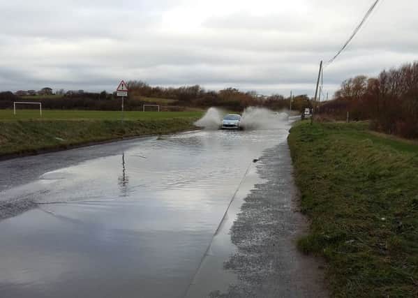 Cars drive through water on Freshfields, leading to the landfill site, in St Leonards SUS-161120-154541001