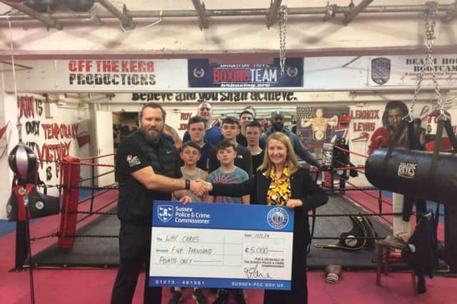 Sussex PCC Katy Bourne (right) presents WBC Cares chairman Scott Welch (left) with funding to help support his boxing programme for at risk youths