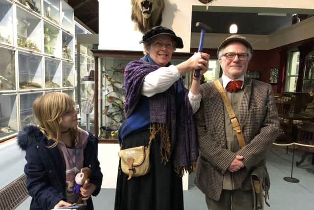 Ava Boud with Mary Anning (Penny Balchin) hitting Mr Booth (Peter Tarshis) with her geologist hammer