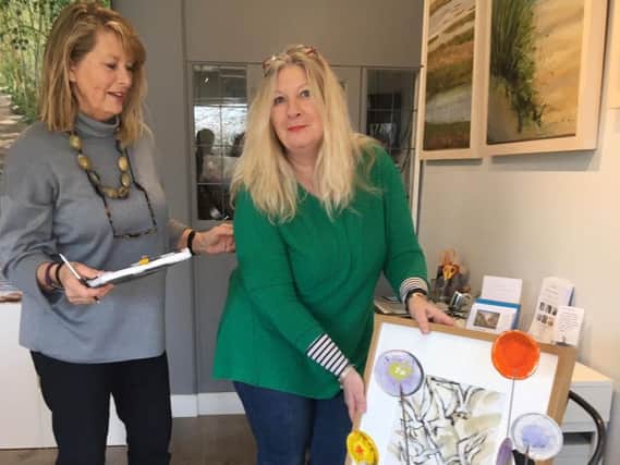 Karen Ongley-Snook (in green) delivering artwork to gallery assistant Lisa Kingwell