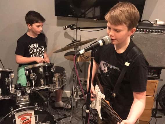 Singer and guitar player Sam Holder, aged ten, and brother Ben on drums, aged nine, playing in their band Lightning