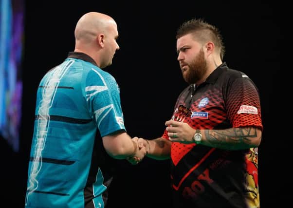 Rob Cross (left) shakes hands with Michael Smith at the end of their match in Aberdeen tonight. Picture courtesy Steve Welsh/PDC