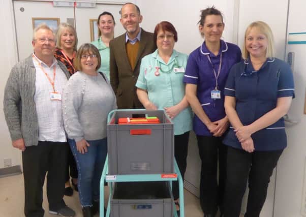 Simon Nelson (centre) at the handover of the trolley with volunteers and the Judy Beard Unit Team SUS-191203-132310001