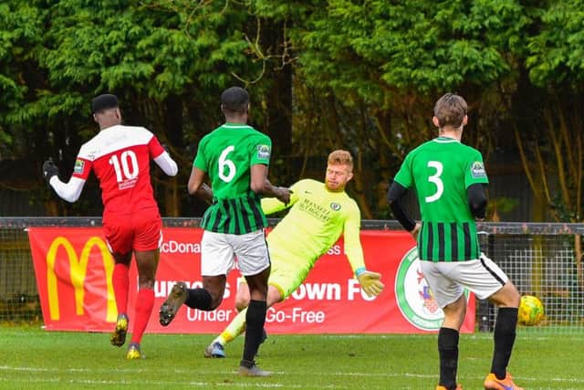 Shaun Okojie (in red) nets for Leatherhead.