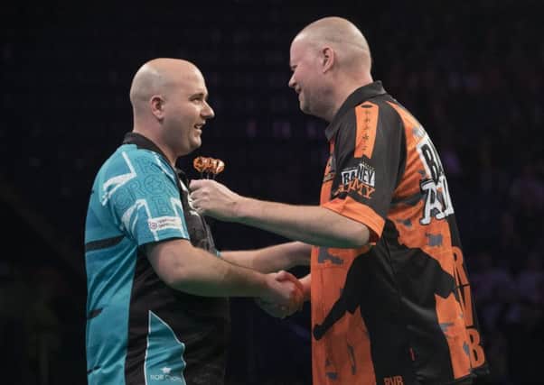 Rob Cross (left) shakes hands with opponent Raymond van Barneveld in Nottingham tonight. Picture courtesy Lawrence Lustig/PDC