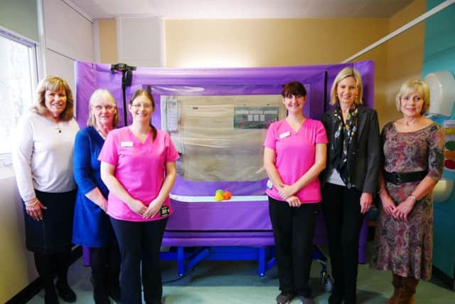 Team members from both charities presenting the bed to Howard Ward