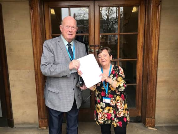 Councillors Ann Bridges and George Barton hand the petition to save the bus to county hall in Chichester