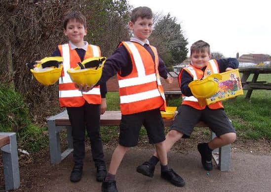Children from the school wearing the high-vis jackets and hard hats and proudly showing the lego that was donated by Mackley