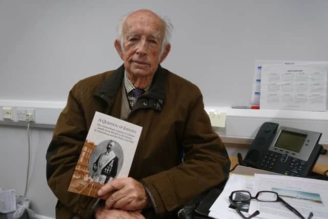 Tim Parker with a copy of his book, A Question of Identity SUS-190104-141909001