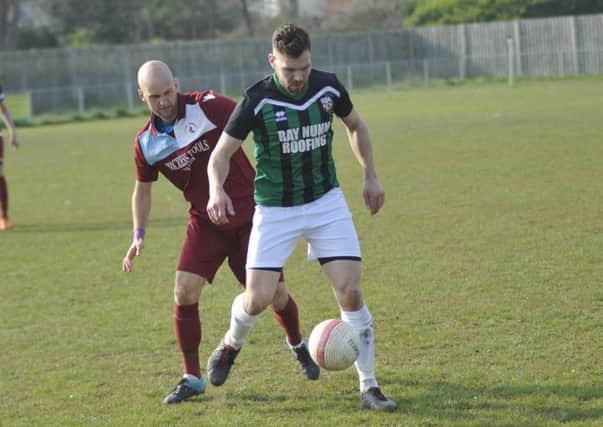 Little Common player-manager Russell Eldridge closes down a Pagham opponent. Picture by Simon Newstead