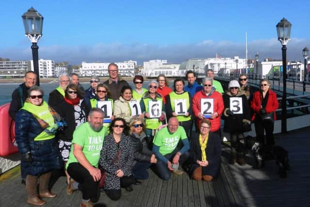 Volunteer from Worthing Samaritans on Worthing Pier, emphasising the free phone number 116 123