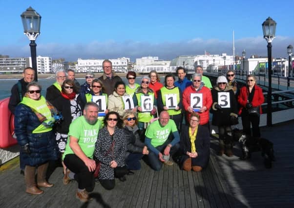 Volunteer from Worthing Samaritans on Worthing Pier, emphasising the free phone number 116 123