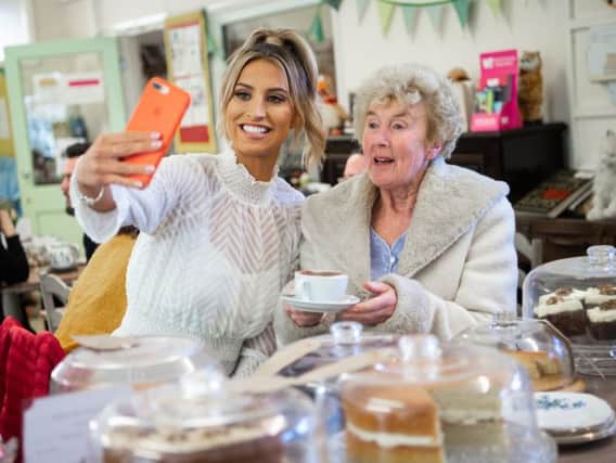 Ferne McCann takes a selfie with Shirley Margaret Hill, at a Royal Voluntary Service Centre in Lancing. Photo: Matt Crossick/PA Wire