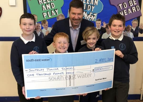 Southway Junior School council members receive a £1,000 donation from South East Water communications officer Chris Laming.