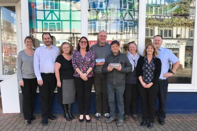 The show's creators, Tim Crouch and Toby Jones (centre and centre right), with staff at Wood's Travel Ltd