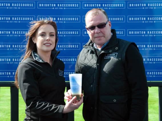 Brighton Racecourse's catering manager Kristy Cutler and executive director Paul Ellison with the new reusable plastic cup. Photograph: Roger Dean