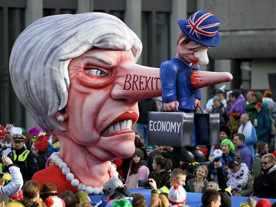 British Prime Minister Theresa May is depicted with a Pinocchio nose reading 'Brexit' piercing a representative of the British economy on a carnival float at the Rose Monday carnival street parade in Duesseldorf, western Germany, on March 4, 2019. Photo credit INA FASSBENDER/AFP/Getty Images