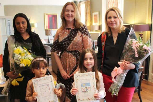 Fiona Murden presents flowers to Nazha Maizi, with daughter Lailah, and Sarah Marchant, with daughter Ayla