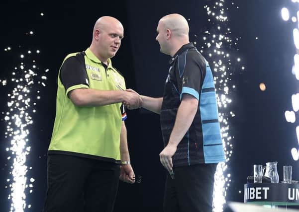 Rob Cross (right) shakes hands with Michael van Gerwen after their match on night three of the Unibet Premier League in Dublin. Picture courtesy Michael Cooper/PDC