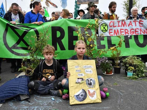 Children sit down at a blockade on Waterloo Bridge during the second day of a coordinated protest by the Extinction Rebellion group