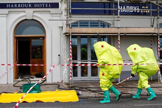 Fire officers put on protective clothing before entering the hotel