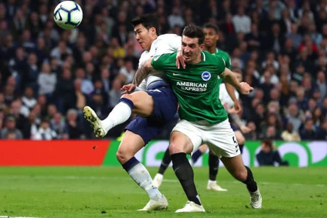 Heung-Min Son of Tottenham Hotspur is challenged by Lewis Dunk of Brighton and Hove Albion. (Photo by Clive Rose/Getty Images